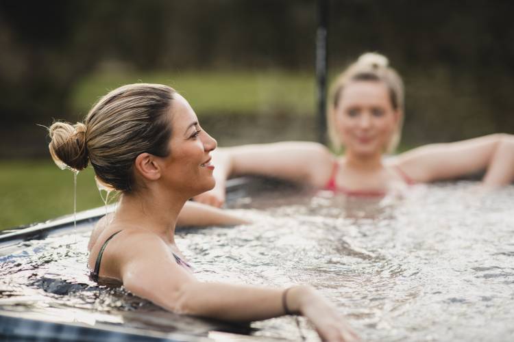 Two women relax as they soak in a hot tub