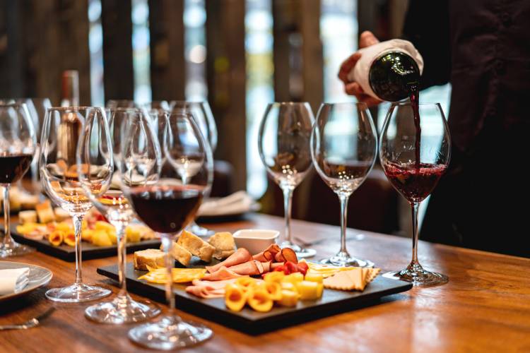 A sommelier pours wine for wine pairing with cheese